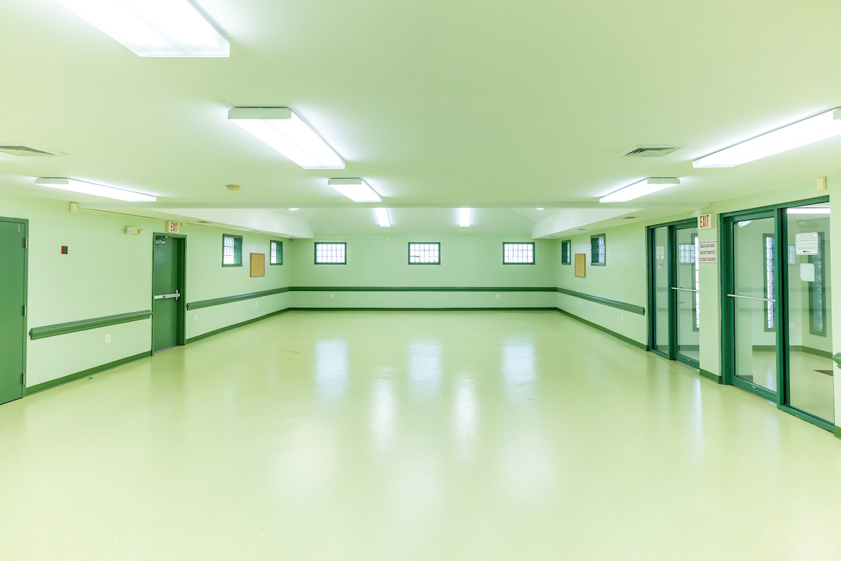 An empty tiled room with doors along two walls.