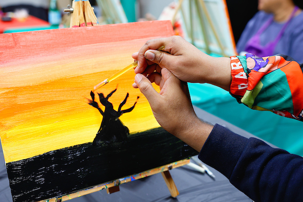 participant being assisted with painting