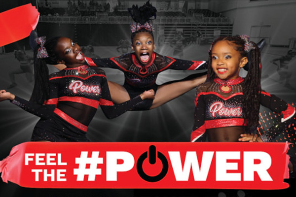 Three young girls doing cheerleading poses. They're wearing black and red outfits. The words "Feel the Power" is across the bottom