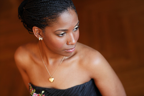 Headshot of a woman in a strapless gown wearing a gold necklace.