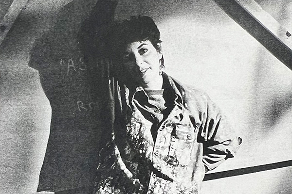 Black-and-white headshot of a smiling woman with short dark hair.