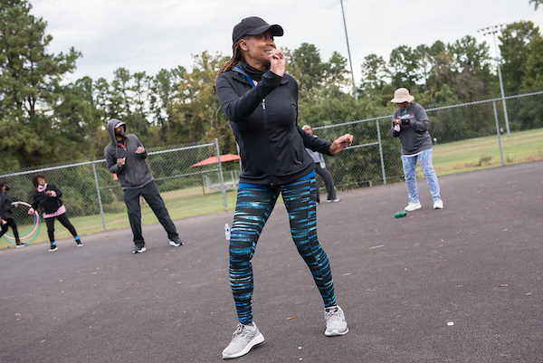 Participants exercise outdoors during a Get Fit Mobile fitness class at a community park.